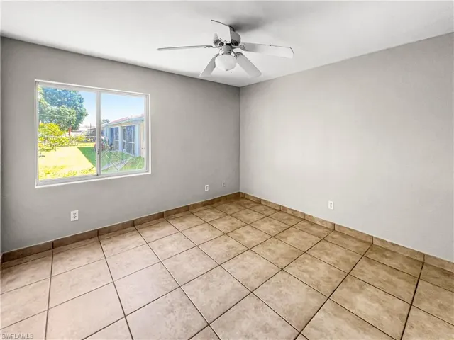 Room featuring neutral wall tones, large format ceramic tile flooring, and a ceiling fan