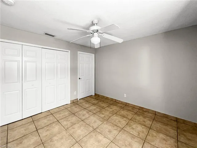 Room featuring neutral-toned walls, tile flooring, and a ceiling fan with integrated lighting