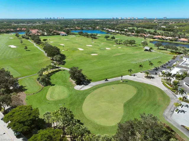Aerial view of property and surrounding area with a nearby body of water and a golf course
