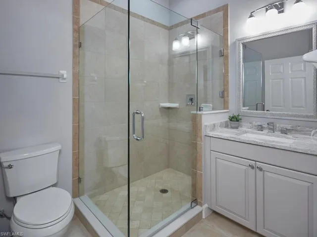 Full bathroom featuring a stall shower, vanity, and light tile patterned floors