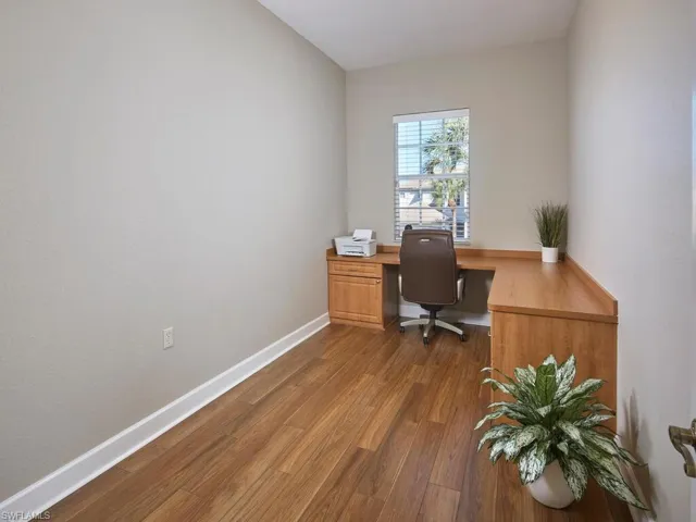 Office space featuring dark wood-style floors and baseboards