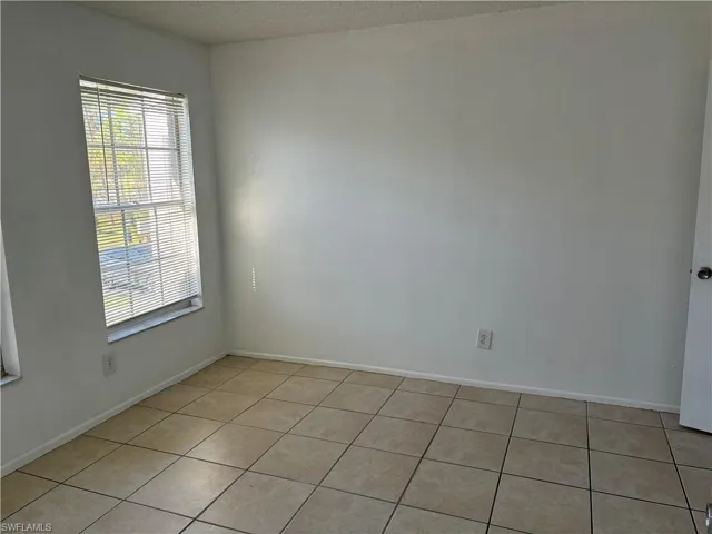 Tiled empty room featuring a textured ceiling