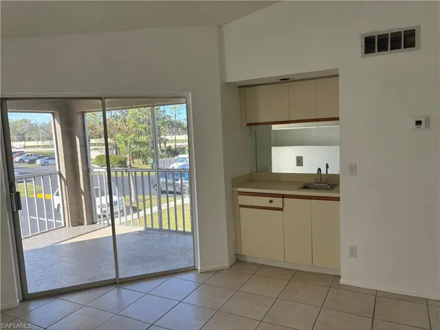 Kitchen featuring light tile patterned flooring, sink, a wealth of natural light, and cream cabinets