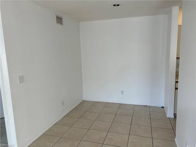 Tiled empty room featuring a textured ceiling