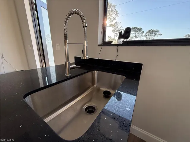 Kitchen view of dark stone countertops and a sink