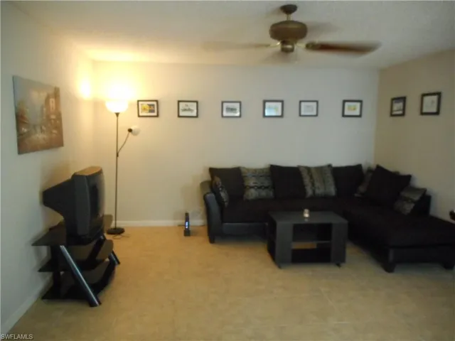 Living area featuring baseboards and a ceiling fan