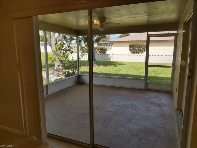 Unfurnished sunroom with healthy amount of natural light, a ceiling fan, and a water view