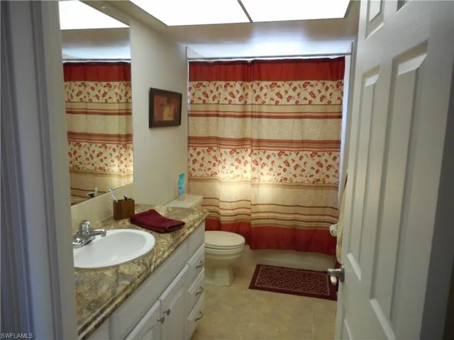 Bathroom featuring vanity, a shower with curtain, and light tile patterned floors