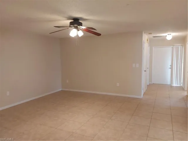 Spare room featuring ceiling fan and baseboards