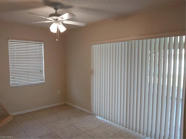 Unfurnished room featuring a ceiling fan, a textured ceiling, and light tile patterned flooring