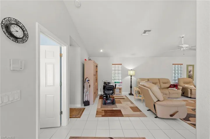 Bright interior space featuring white tile flooring, white walls, and recessed lighting