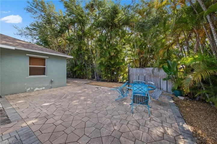 Expansive paved patio featuring geometric stone pavers and a brick border