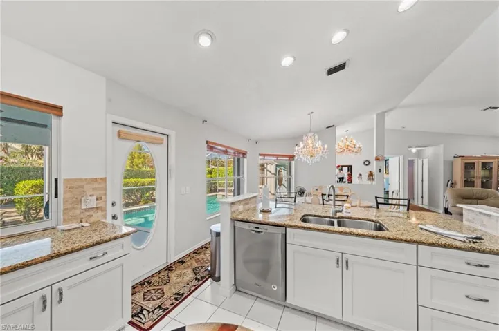 Kitchen featuring white cabinetry, granite countertops, stainless steel appliances, and a dual basin sink