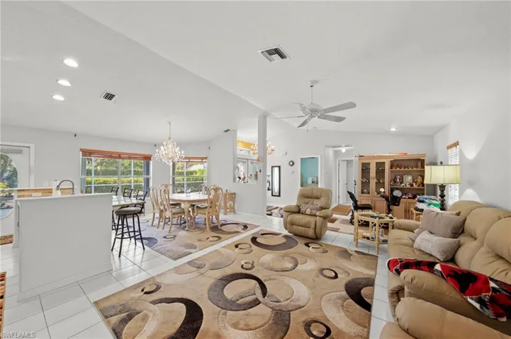 Bright interior featuring white tile flooring and vaulted ceilings
