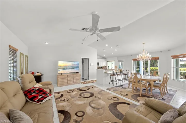 Open-concept living area with white tile flooring and recessed lighting