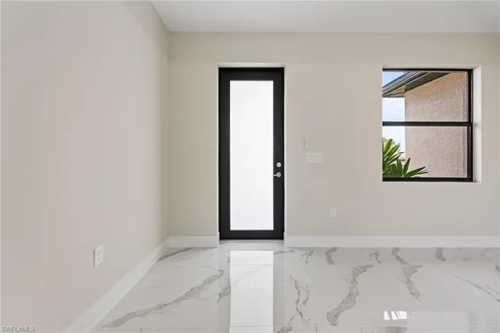 Entrance foyer with light marble finish flooring and baseboards