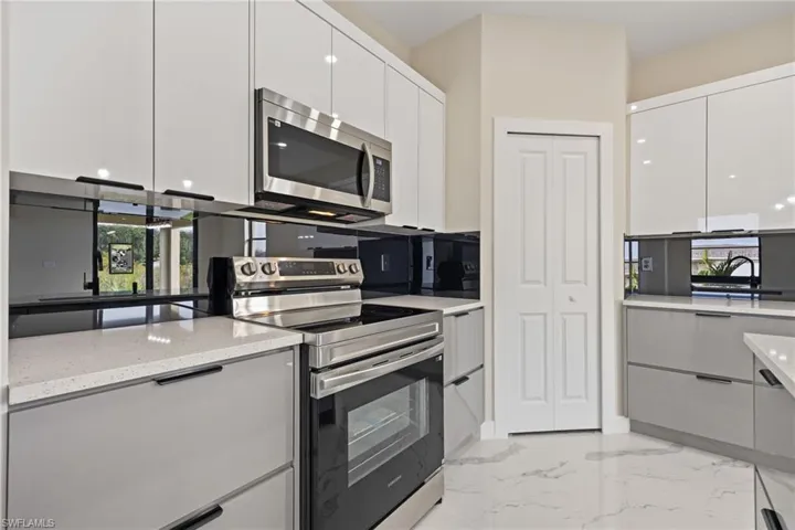 Kitchen with stainless steel appliances, modern cabinets, healthy amount of natural light, and white cabinetry
