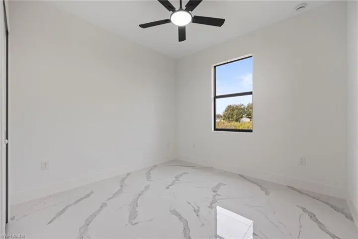 Empty room with baseboards and ceiling fan