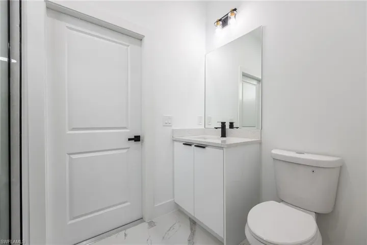 Bathroom featuring vanity and light marble finish flooring