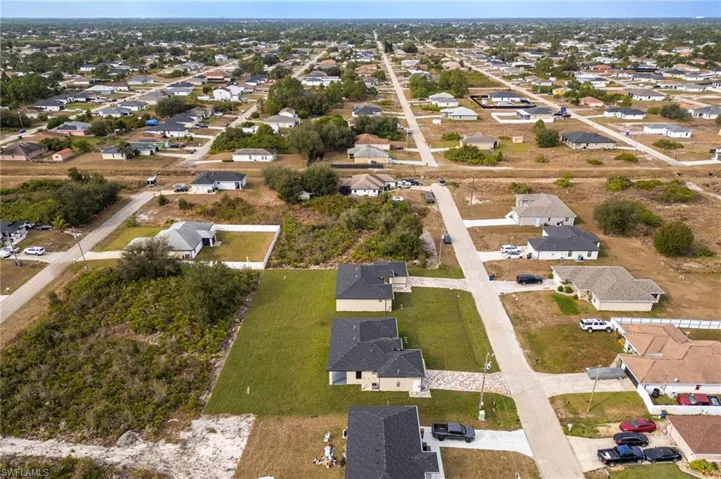 Aerial view of property and surrounding area featuring nearby suburban area