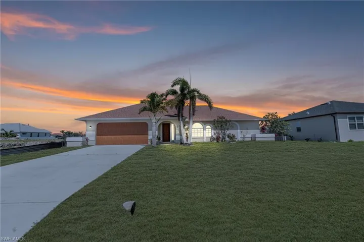 Ranch-style house with an attached garage, concrete driveway, a yard, and stucco siding