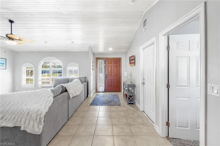 Entrance foyer featuring ceiling fan, light tile patterned floors, and wooden ceiling