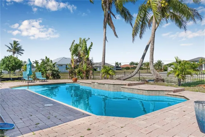 View of pool with a patio and fence
