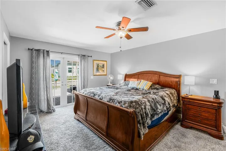 Bedroom with light carpet, access to exterior, french doors, and a ceiling fan