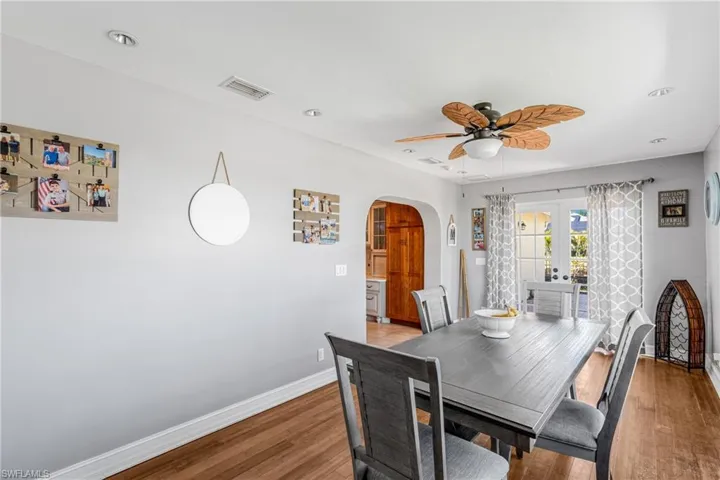 Dining space featuring arched walkways, baseboards, ceiling fan, light wood finished floors, and recessed lighting