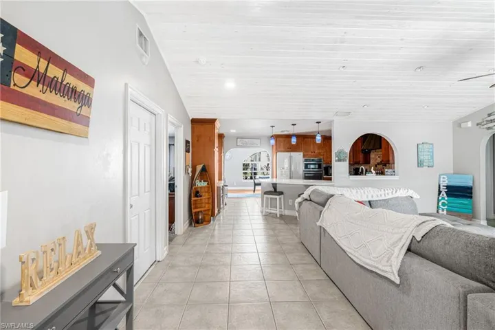Living area with light tile patterned flooring, recessed lighting, and wood ceiling