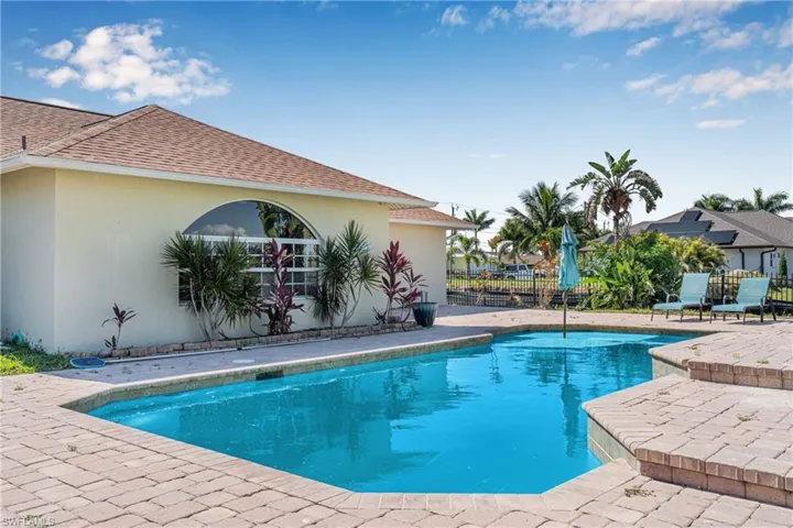 Outdoor pool with fence and a patio area