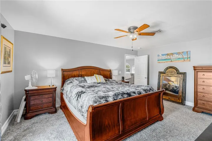 Bedroom featuring light colored carpet, baseboards, and ceiling fan