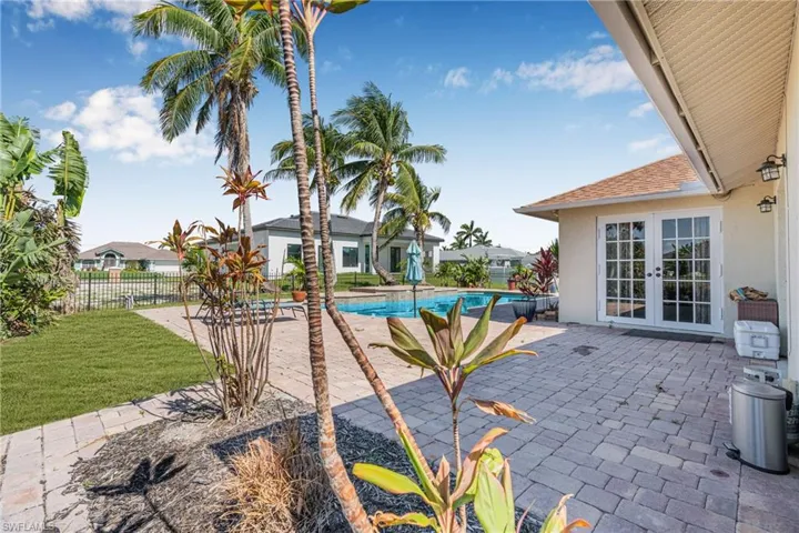 View of swimming pool with french doors and a patio area