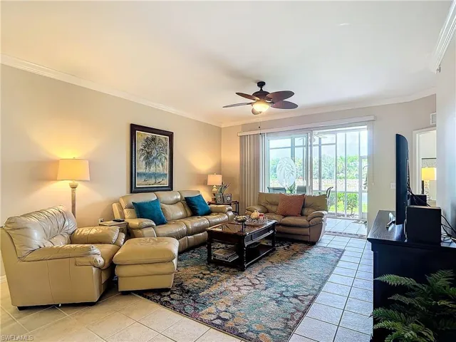 Tiled living room featuring crown molding and ceiling fan