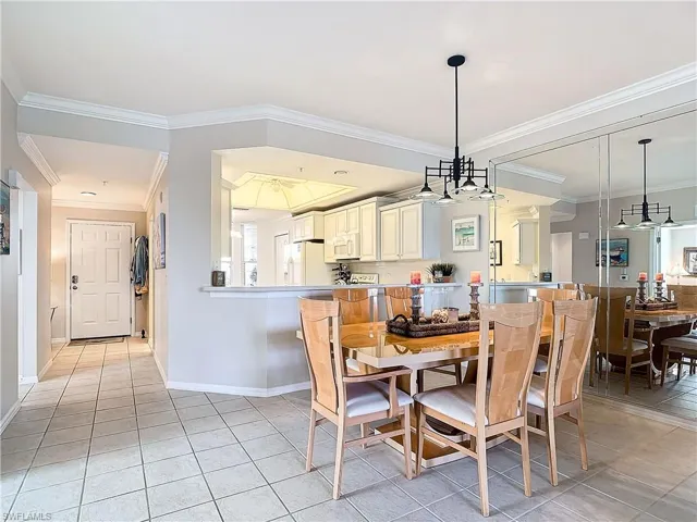 Dining room with ornamental molding and light tile patterned floors