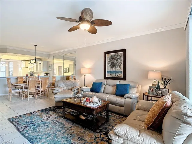 Tiled living room with crown molding and ceiling fan