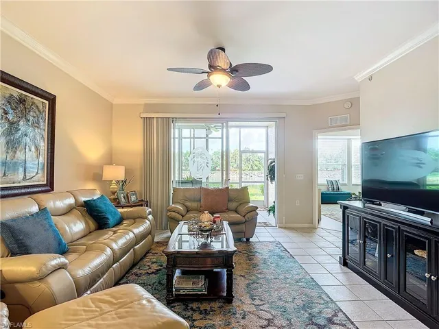 Tiled living room with crown molding and ceiling fan