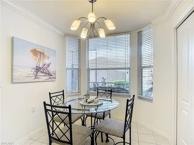 Dining area with a chandelier, crown molding, and light tile patterned floors