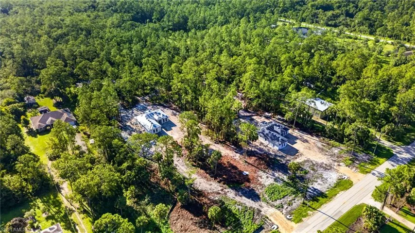 Expansive wooded landscape featuring multiple building sites with new construction in progress