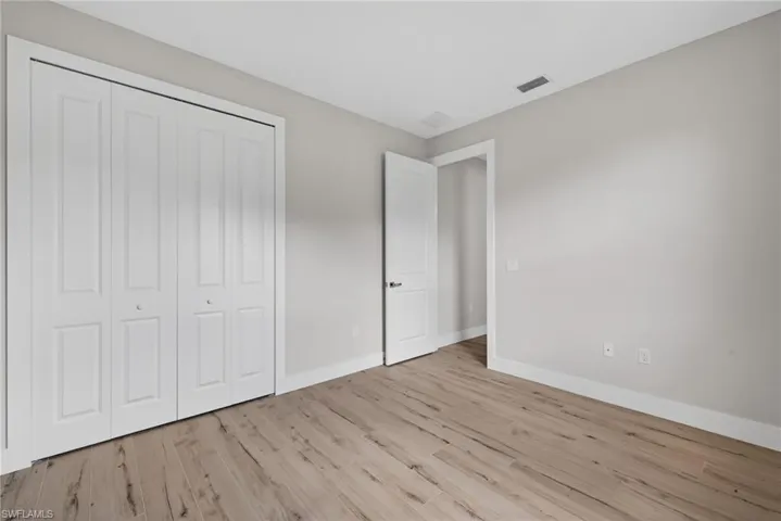 Interior room featuring wood-finish flooring, light grey painted walls, and white trim