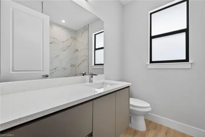 Contemporary bathroom featuring a light speckled countertop, under-mount sink, and chrome faucet