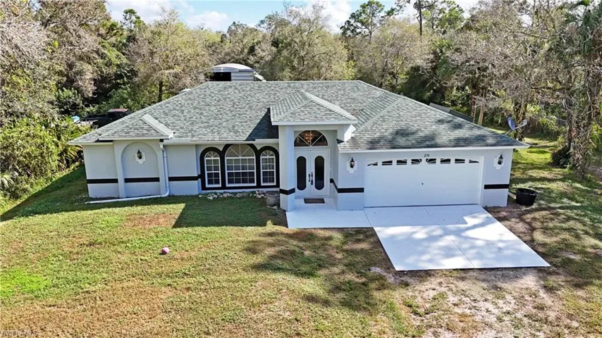 View of front facade featuring a front lawn and a garage