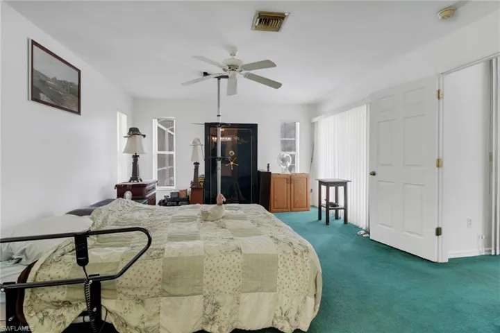 Carpeted bedroom featuring ceiling fan