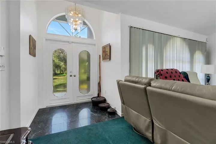 Foyer with french doors, a towering ceiling, and an inviting chandelier