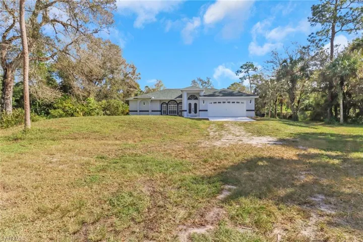 View of front of house featuring a front lawn and a garage