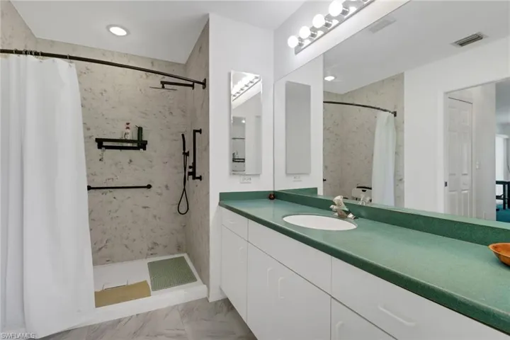 Bathroom featuring curtained shower and vanity
