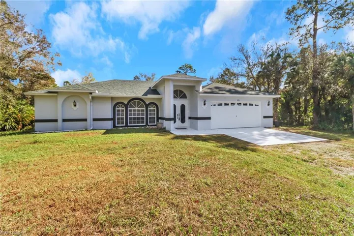 View of front of property with a front lawn and a garage