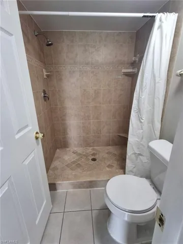 Full bath featuring light tile patterned flooring and a stall shower