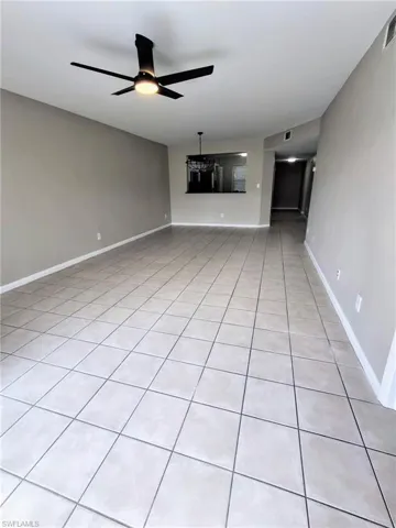 Unfurnished living room featuring light tile patterned floors and ceiling fan