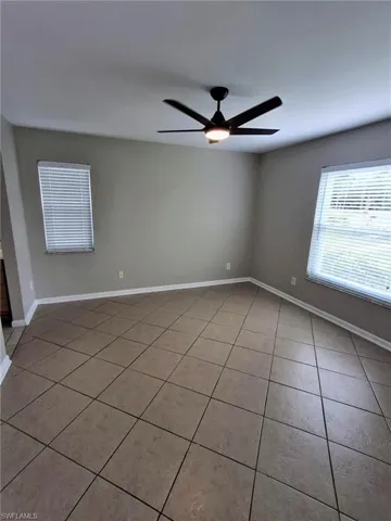 Empty room featuring light tile patterned floors and a ceiling fan